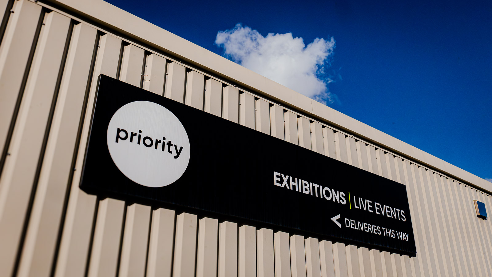 Priority Exhibitions exterior signage with the refreshed identity
