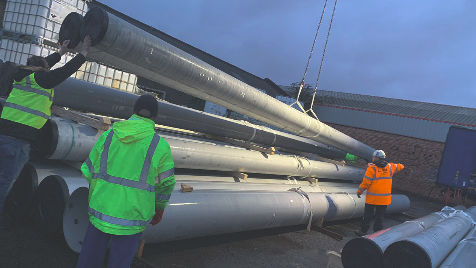 Anopol team handling large stainless-steel pipework
